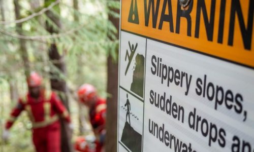 a sign warning of slippery slopes in the woods